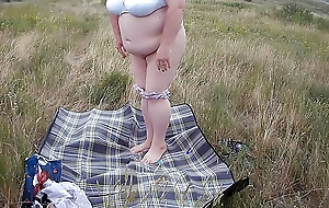 fat woman masturbates with a plaything in the field